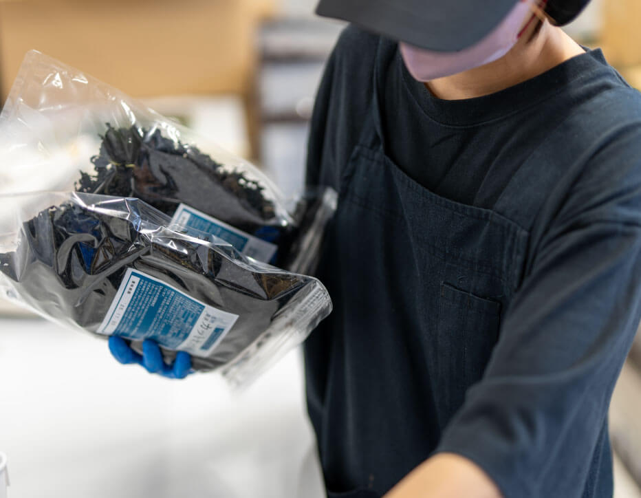 製品を手に持つスタッフ